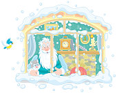 Good old magician and his little kitten looking out of a snow-covered window in their old village house from a fairy tale, vector cartoon illustration isolated on a white background