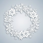 Greeting card with beautiful Christmas wreath made with white snowflakes.