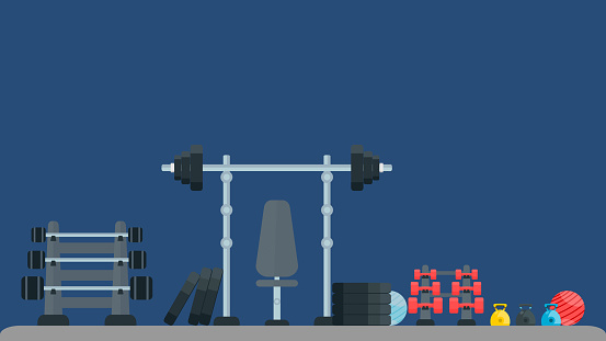 Gym fitness equipments; weight, dumbbell, kettlebell, pilates ball, barbell and bench in gym. Healthy lifestyle exercise and sports concept. Dark blue background.