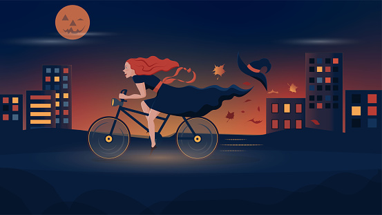 Halloween. Joyful witch rides a bicycle through the night city