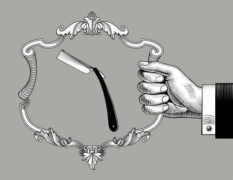 Hand holding a baroque decorative frame with a straight razor