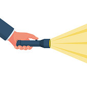istock Hand holding flashlight. Search concept. Yellow bright ray of light. 1174960543
