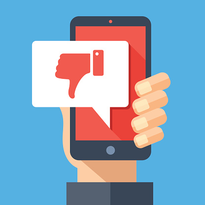Hand holding smartphone with dislike message, dislike button. Thumbs down icon. Social networking, social media usage on mobile device. Concept for website, web banner. Flat design vector illustration