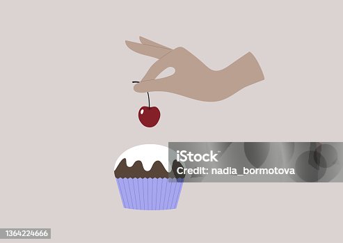 istock A hand putting a red sweet cherry on top of a muffin with a vanilla icing 1364224666