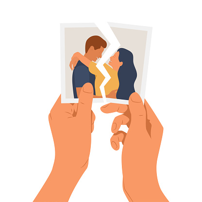 Hands holding a torn photo of a couple in love
