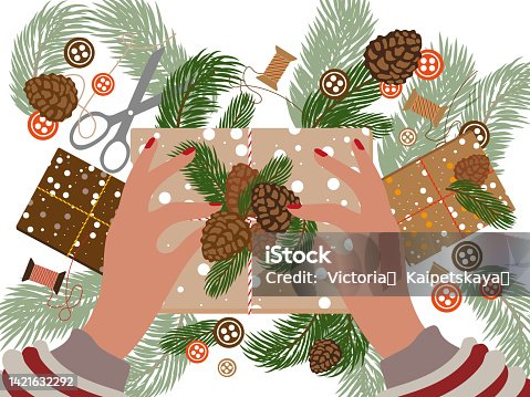 istock Hands woman wrapping Christmas gift boxes 1421632292