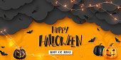 Happy Halloween horizontal banner. Pumpkins with monster faces, paper clouds, flying bats and garland. Handwritten lettering, orange background. Vector illustration.