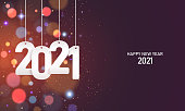 Happy new year 2021. Hanging white paper number with confetti on a colorful blurry background.