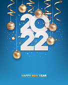 Happy new year 2022. White paper numbers with golden Christmas decoration and confetti on blue background. Holiday greeting card design.
