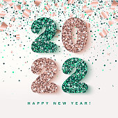 2022 Happy New Year festive Banner with glowing rose gold and emerald Numbers on falling geometric foil paper confetti background. Vector illustration. All isolated and layered
