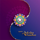 Decorated rakhi for Indian festival Raksha Bandhan Greeting Card ,indian festival with gold patterned and crystals on paper color Background.