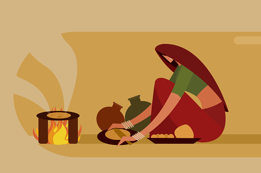 Indian woman making 'Roti' in traditional way on a fire stove