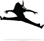 A young girl jumps into the air and does a split.