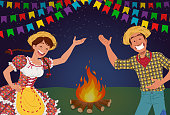 Man dressed in plaid shirt and woman wearing floral peasant dress for traditional brazilian party celebrated in June.