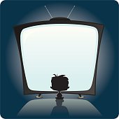Silhouette of small child in front of an oversized television set.