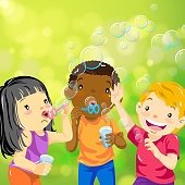 Multi-ethnic group of children blowing bubbles.