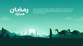 Landscape illustration of Ramadan Mubarak with calligraphy, silhouette of mosque and traveler carrying camel in desert