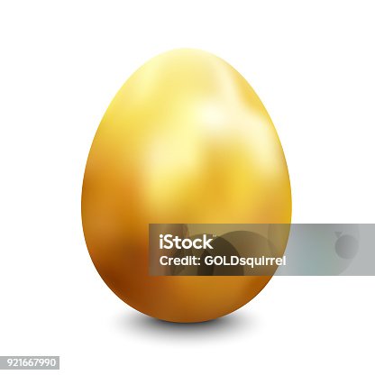 istock Large oval gold painted chicken egg standing vertically on a white surface lit up from the top casting a shadow 921667990