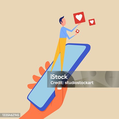 istock Man holding like button with mobile phone 1335462145