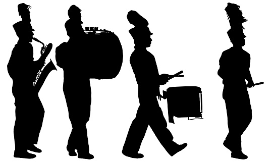 Silhouettes of marching band musicians walking and playing instruments