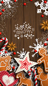Mobile phone Christmas wallpaper, gingerbread cookies, ornaments, candy canes and anise stars laying on wooden background, with text Let it snow, vector illustration, eps 10 with transparency
