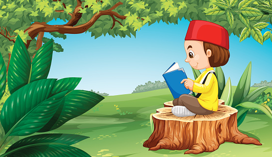Muslim boy reading book in park