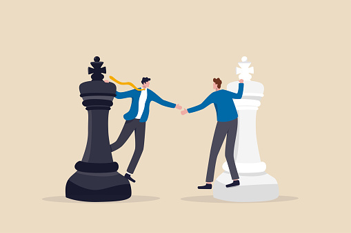 Negotiation strategy, win-win situation, partnership instead of confrontation in competition, merger or agreement concept, businessman competitors standing on chess handshaking after finish agreement.