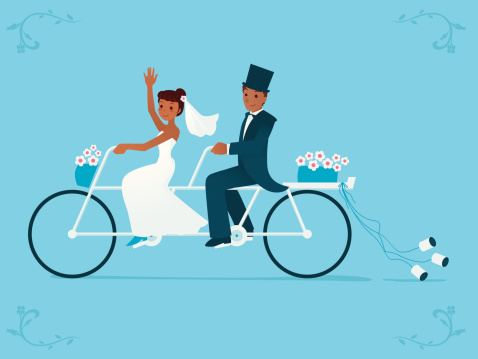 Newlywed bride &amp; groom riding on a Tandem bicycle