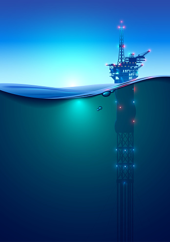 Oil offshore Drilling Platform in the ocean at dawn. Beautiful background for oil industry. Oil rig in the light of lanterns and spotlights. Split view over and under water surface. Classic spar.