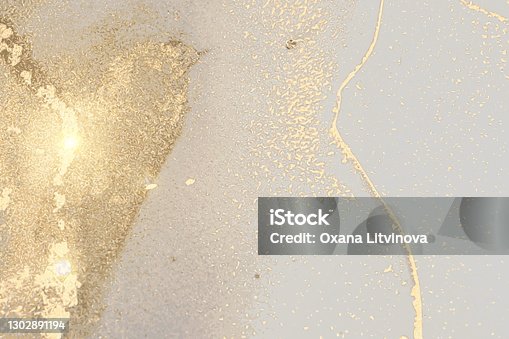 istock Pale grey and gold stone marble texture with glowing lights. Alcohol ink technique 1302891194