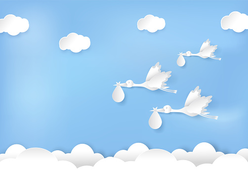 Paper art of stork flying with baby on blue sky paper cut style illustration