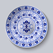 istock Porcelain plate with blue round ornament in ethnic style. Decorative pattern in the style of national flower painting. Ornate floral decor. Realistic 3D decor. 1324294034