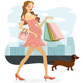 Beautiful pregnant woman carrying shopping bags walking along with her dachshund dog on a city background.