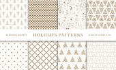 Set of winter holiday seamless patterns. Merry Christmas and Happy New Year. Collection of simple geometric textured backgrounds with golden color. Vector illustration. EPS 10