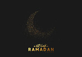 Ramadan background. Design is sand with golden squeak of silhouette half month. black pattern with bright sequins loose gold. Arabic calligraphic text of Ramadan Kareem