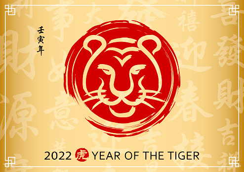 Celebrate the Year of the Tiger 2022 with tiger head Chinese painting on the gold colored Chinese language background, the vertical Chinese phrase means year of the tiger according to lunar calendar system and the red stamp means tiger