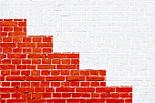 A white and red colored brick wall with rectangular blocks, textured grungy backgrounds. No text. No people, copy space, copyspace.  There are three red stripes of varying heights  at the bottom edge of the frame, making a red colored painted winner's podium. The masonry joints joint are white in color.  Xmas, Christmas theme backgrounds