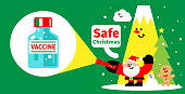 istock Santa Claus is shining a flashlight showing the coronavirus vaccine bottle, Covid-safe Christmas concept 1353920403