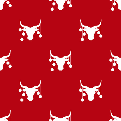 Seamless pattern. Bull head with red christmas tree toy balls on horns, snow and stars.