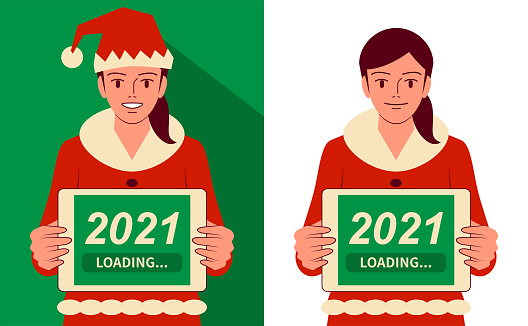 Smiling beautiful teenage girl dressed in a Santa Claus suit holding a digital tablet with "2021 Loading" words on screen