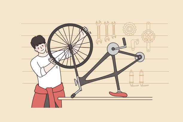ilustraciones, imágenes clip art, dibujos animados e iconos de stock de hombre sonriente repara bicicleta en pequeño taller - small business saturday