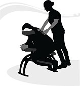 A vector silhouette illustration of a man getting a massage in a massage chair from a young female massuse.