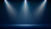 istock Spotlight backdrop. Illuminated blue stage. Background for displaying products. Bright beams of spotlights, shimmering glittering particles, a spot of light. Vector illustration 1322502570