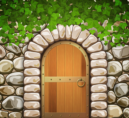 Stone wall with arched medieval wooden door and leaves