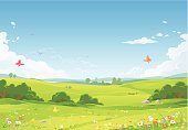 A summer or spring landsapce with green meadows, flowers, hilly fields and a blue sky with clouds in the background. EPS 8, fully editable and all labeled in layers.