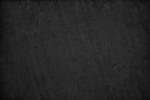 Grungy black and gray grey color old scratched effect background. Vertical scratch marks and vignetting at the corners and edges. Crevices and blotches give the effect of a slate or blackboard.