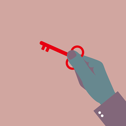 The key is in the hand. Isolated on brown background.