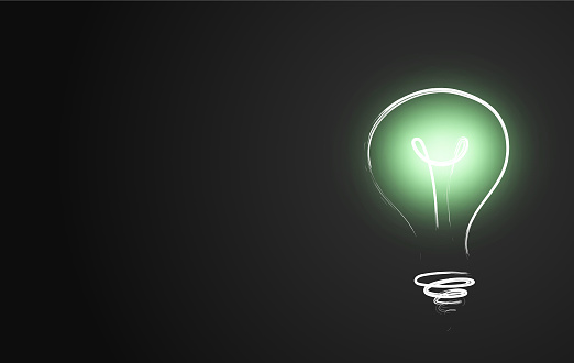 A chalk doodle of a light bulb shining a bright green light on a dark background. Green energy. Ecological ideas.