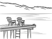 Two chairs on a dock overlooking a lake