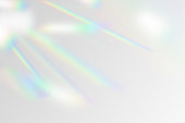 Vector illustration of rainbow flare overlay effect mockup. Blurred reflection crystal rays, shadows and flash on background. Natural iridescent light backdrop.